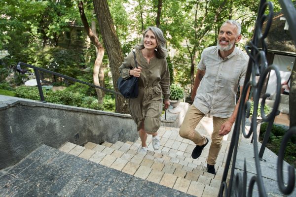 Older adult couple climbing stairs outside